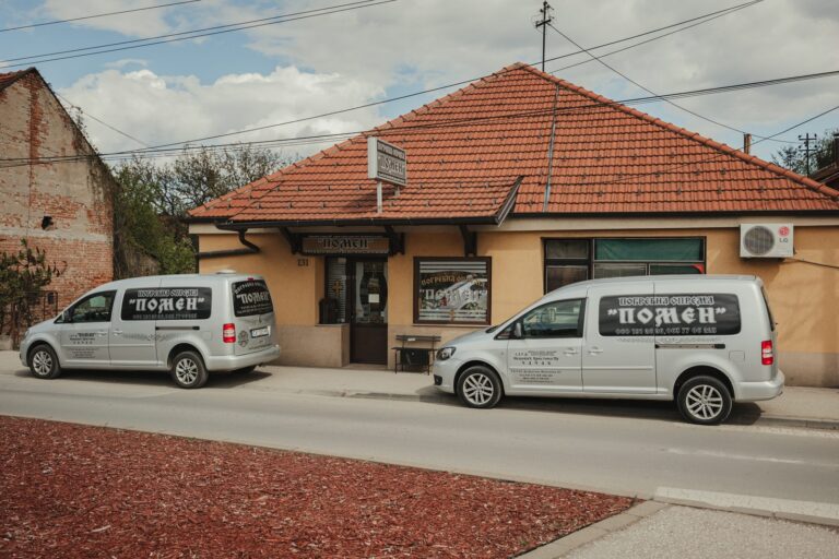 Dva vozila Pogrebne opreme Pomen ispred zgrade u Dragiše Mišovića 131